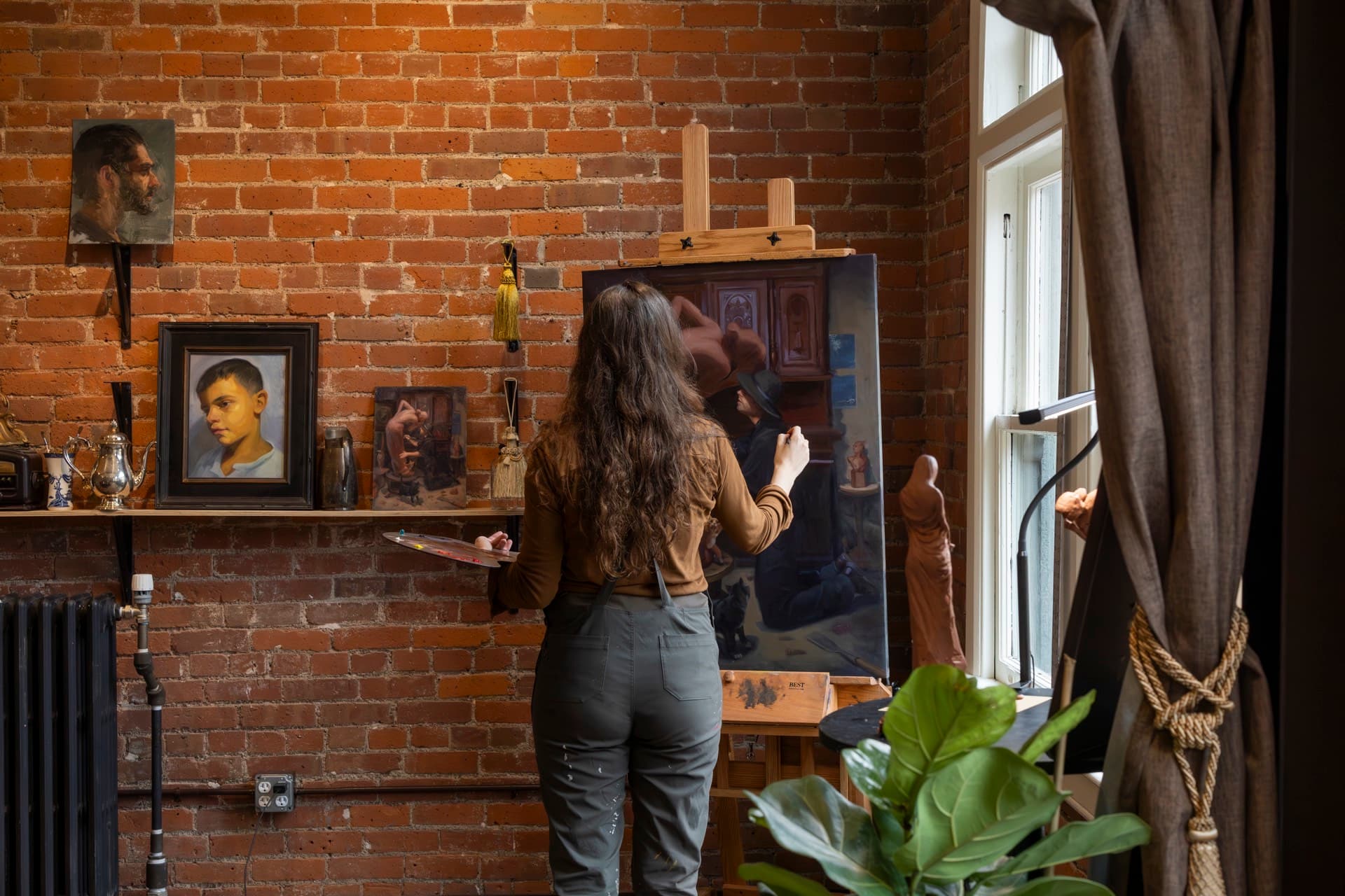 An artist at work on a portrait at the Occidental Fine Arts Center