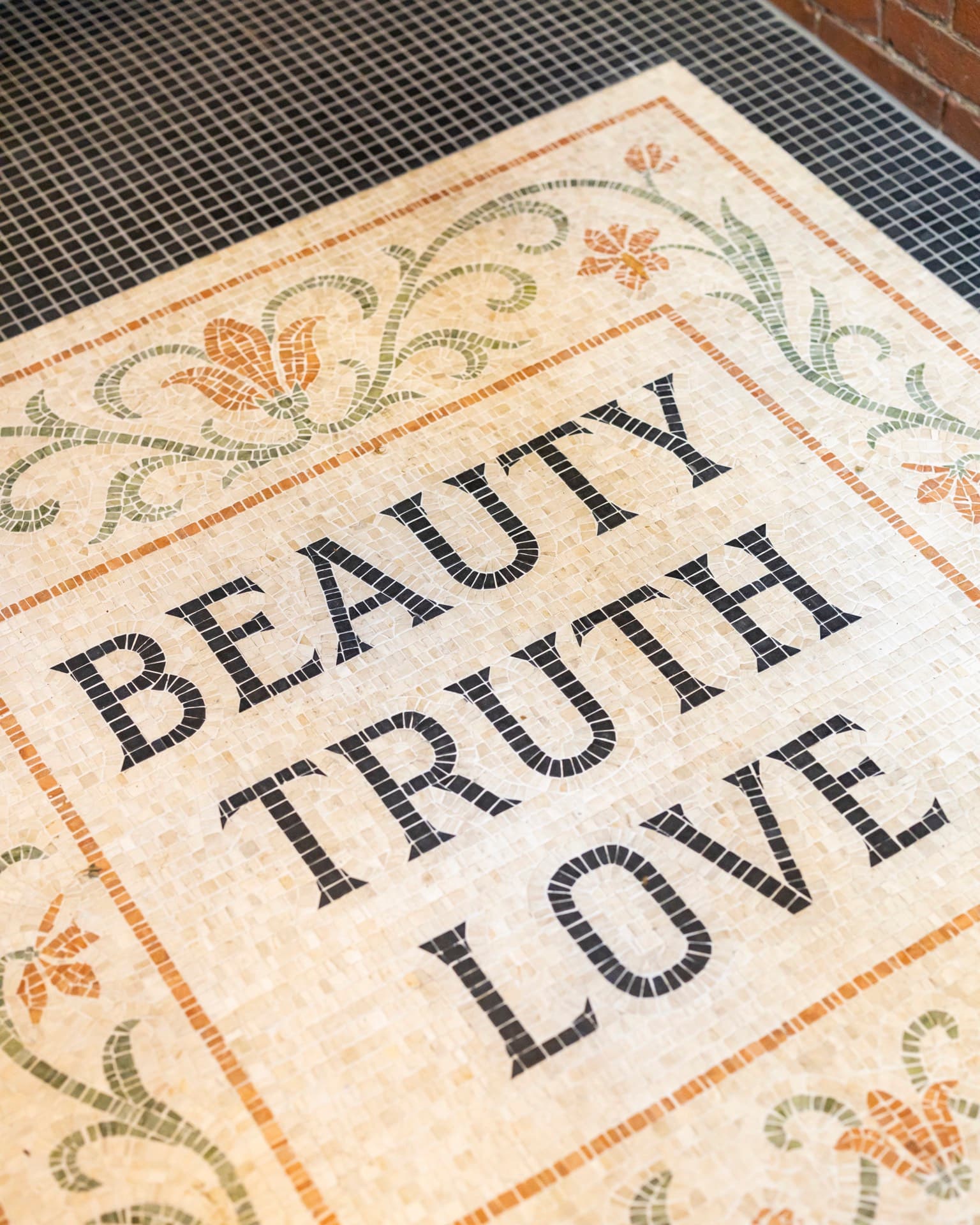 The mosaic in the Occidental’s entry floor, set with the words Beauty, Truth, Love